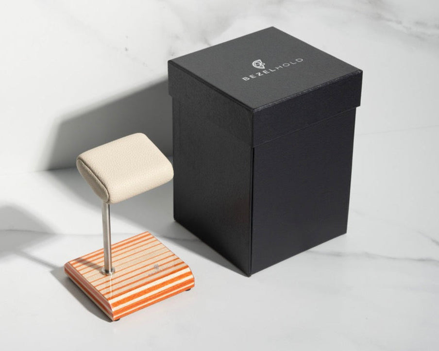 white leather and orange watch stand with gift box