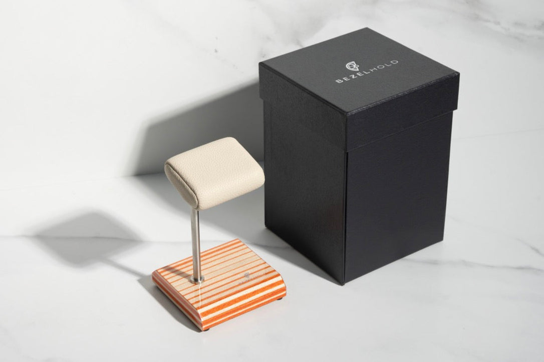 white leather and orange watch stand with gift box